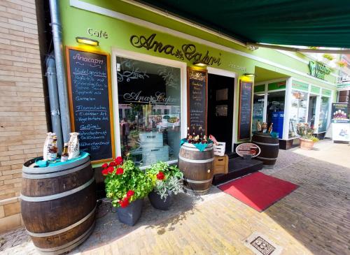 a store front of a store with barrels and flowers at AnaCapri Gästehaus Florenz in Ueckermünde