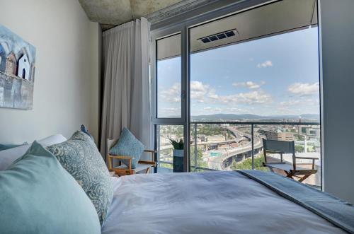 a bedroom with a bed and a large window at Les Immeubles Charlevoix - Le 760-612 in Quebec City