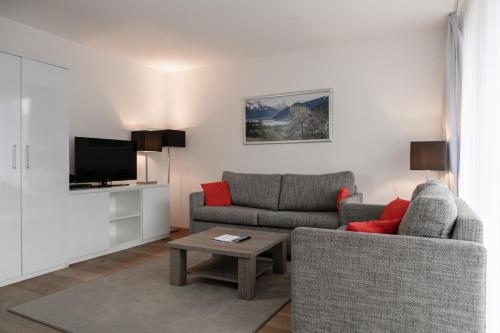 a living room with two couches and a tv at Residence Bellevue - incl Summercard in Zell am See