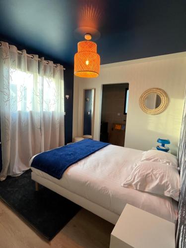 a bedroom with a large bed with a blue blanket at La Belle Mélorienne in Saint-Méloir-des-Ondes