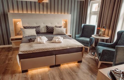1 Schlafzimmer mit einem großen Bett und 2 Stühlen in der Unterkunft AnaCapri Gästehaus Florenz in Ueckermünde