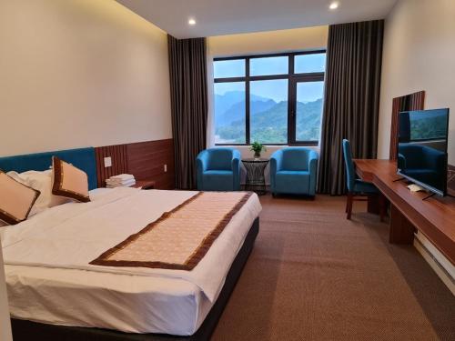 A Sim ba be lake hotel في Bak Kan: غرفة فندقية بسرير وتلفزيون بشاشة مسطحة