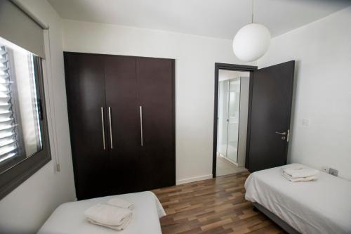 1 dormitorio con 2 camas y armario negro en Glabur Stays - The Amazing 2 BDR - Nicosia City, Free Parking & WiFi, en Nicosia
