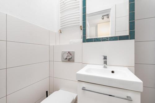 a white bathroom with a sink and a toilet at Broniewskiego 24A by Homeprime in Warsaw