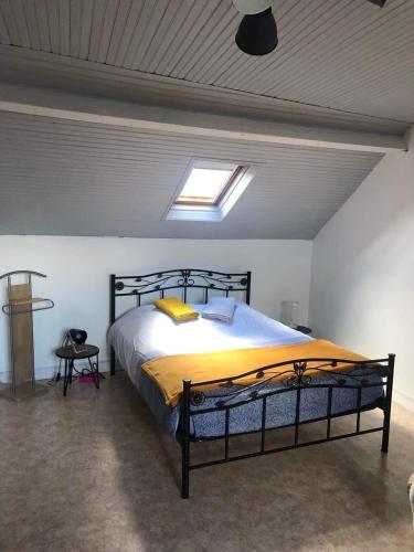 une chambre avec un grand lit avec une couverture jaune dans l'établissement La Parenthèse - maison Tréportaise avec cour fermée, au Tréport