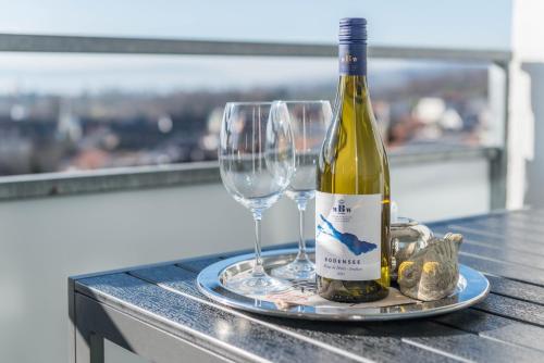 a bottle of wine and two glasses on a table at Bodenseepanorama Oberuhldingen in Uhldingen-Mühlhofen