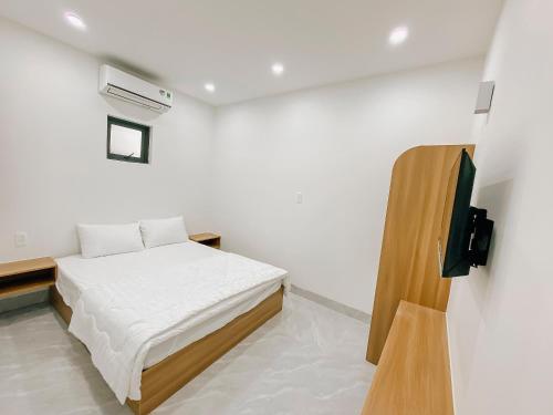 a white room with a bed and a tv at Family Homestay Quy Nhon in Quy Nhon