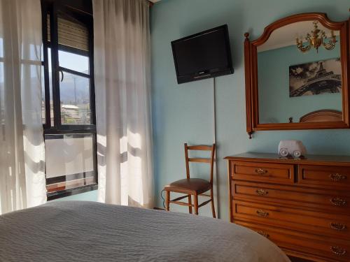 ein Schlafzimmer mit einem Bett, einer Kommode und einem Spiegel in der Unterkunft Apartamento Brañavalera in Pola de Lena
