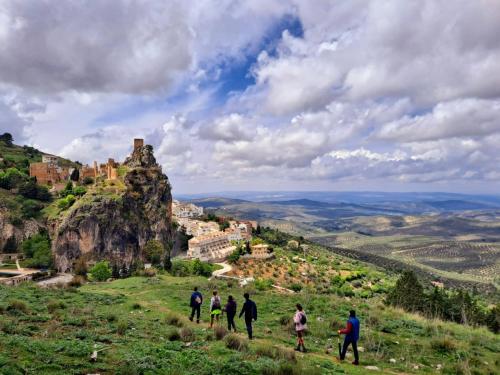 a group of people walking on a hill with a castle at Hotel El Curro in Burunchel