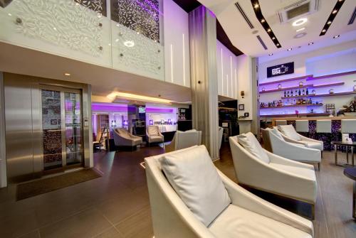 ein Restaurant mit weißen Stühlen und einer Bar in der Unterkunft Hotel Srbija Garden Ex Garni in Belgrad