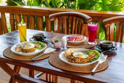 The Kleep Jungle Resort في نوسا بينيدا: طاولة خشبية مع لوحات من المواد الغذائية والمشروبات