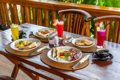 The Kleep Jungle Resort في نوسا بينيدا: طاولة خشبية مع لوحات من المواد الغذائية والمشروبات