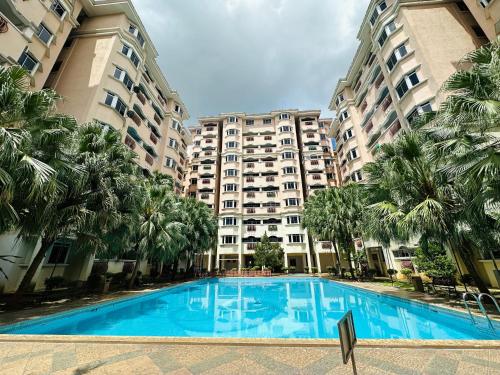 a swimming pool in front of two large buildings at Family apartment in Tawau Town in Tawau