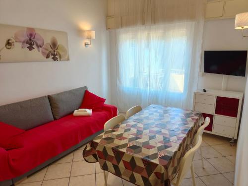 uma sala de estar com um sofá vermelho e uma mesa em Residence Hotel Vittoria em Tirrenia