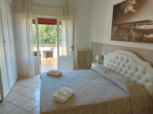 1 dormitorio con 1 cama grande y 2 toallas. en Residence Hotel Vittoria, en Tirrenia