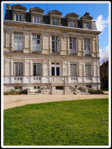 a large stone building with a lawn in front of it at Fief des 3 Guillaume Chambres d'hôtes in Écouis