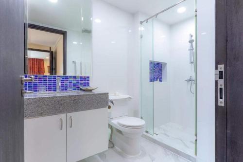 Un baño con inodoro y ducha de cristal. en Citismart Residence, en Pattaya central