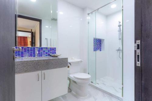 a bathroom with a toilet and a glass shower at Citismart Residence in Pattaya