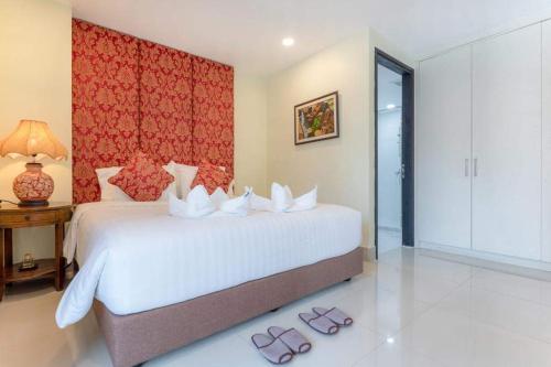 een slaapkamer met een bed en 2 slippers op de vloer bij Citismart Residence in Pattaya