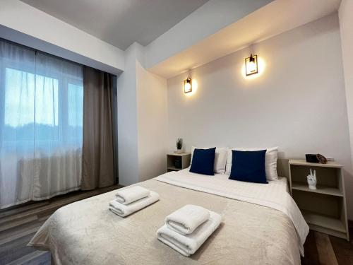una camera da letto con un grande letto con asciugamani di Cozy Deluxe Apartments in Centre of Historical Suceava a Suceava