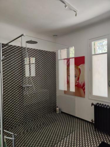 a bathroom with a shower and a painting on the wall at Bastide du château in Montfaucon