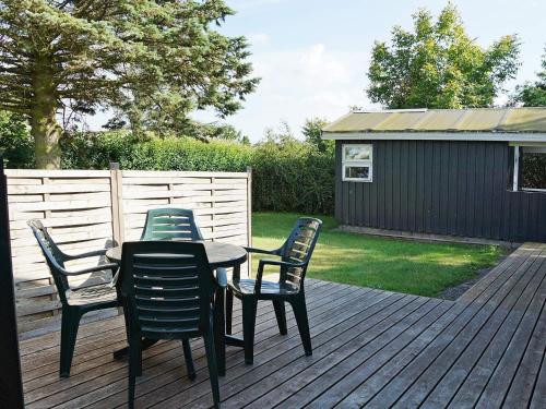 a table and four chairs on a deck at 8 person holiday home in Hesselager in Hesselager