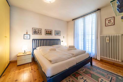 a bedroom with a large bed and a large window at Ai Tabià in Alleghe