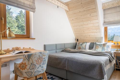 a bedroom with a bed and a desk and window at Góralskie Zaloty - domki widokowe w Koscielisku in Kościelisko