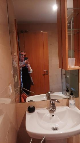 a man taking a picture of a bathroom mirror at TORRE de la FUENTE AprtoVistas Piscina Parking in Oviedo