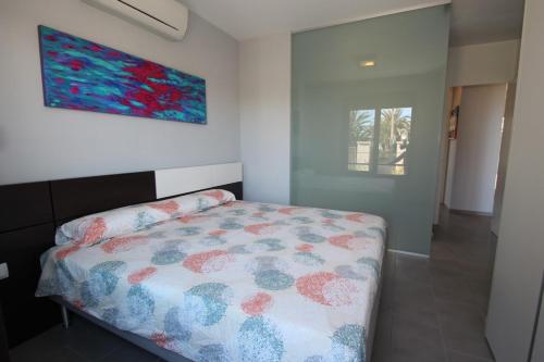 Un dormitorio con una cama y un cuadro en la pared. en Casa D'Alessandro, en Orihuela Costa