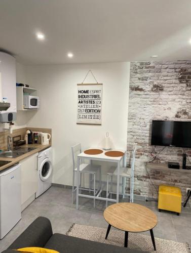 un salon avec une table et une cuisine dans l'établissement Studio 23m2 moderne hypercentre - Arènes à 2 min, à Nîmes
