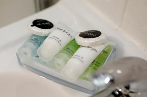 four bottles of toothpaste are sitting in a sink at Bexley Village Hotel in Bexley