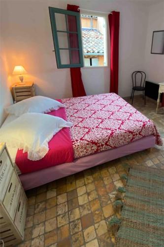 une chambre avec un lit avec une couverture rouge et une fenêtre dans l'établissement Grasse : Centre ville Superbe appartement 2 chambres, à Grasse