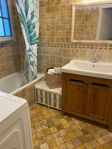 La salle de bains est pourvue d'un lavabo, d'une baignoire, d'un lavabo et d'un miroir. dans l'établissement Grasse : Centre ville Superbe appartement 2 chambres, à Grasse