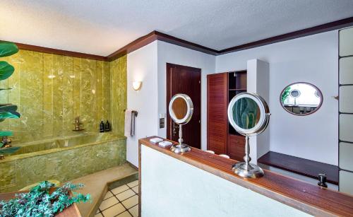 ein Badezimmer mit einem Spiegel und einer Badewanne in der Unterkunft Finest Retreats - Haus Sophie in Schladming