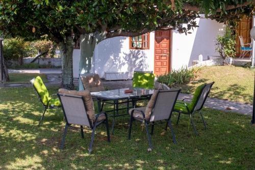 a table and chairs in a yard under a tree at Villa Kontos in Kamena Vourla