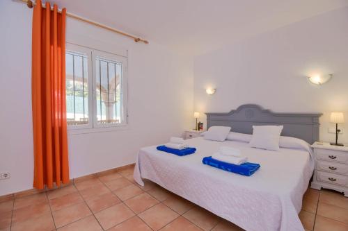a bedroom with a large white bed and a window at Monte Naranja in Jávea