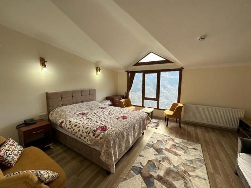 1 dormitorio con cama y ventana grande en MEŞEİÇİ BUTiK HOTEL, en Macka