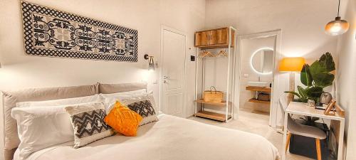 una camera da letto con un letto bianco e cuscini sopra di Almarì a Cagliari