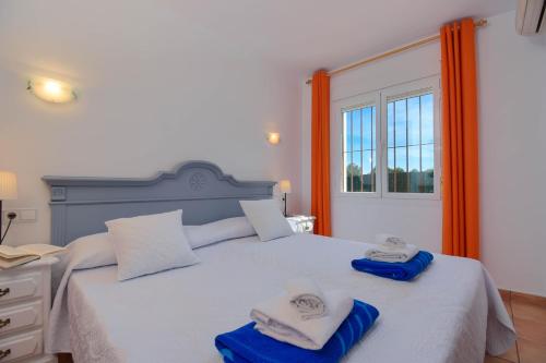 a bedroom with a large bed with towels on it at Monte Rojo in Jávea
