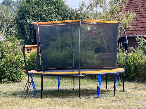 a trampoline with a covering on the grass at Ferienhäuser Insel Usedom Haus Jojo 7 - Blick aufs Achterwasser! Whirlpool und Sauna in Lütow