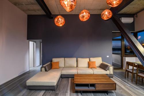 a living room with a couch and some lights at ArtHomes Apartments in Timişoara