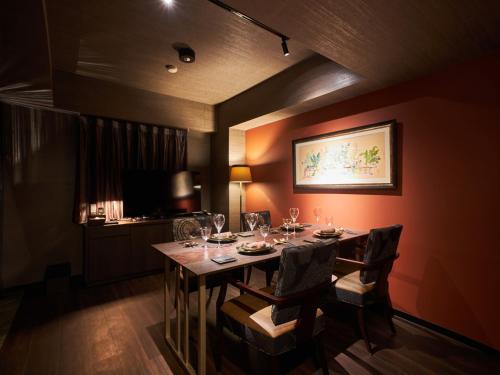 a dining room with a table with wine glasses on it at Roppongi Hotel S in Tokyo