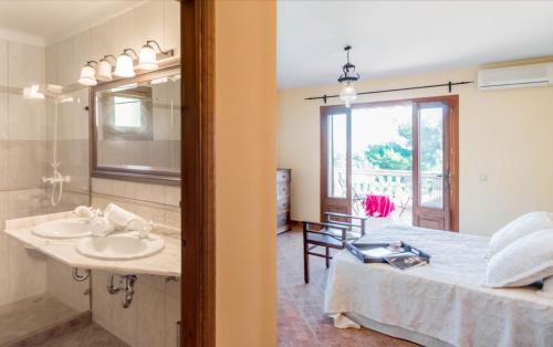 a bedroom with a bed and a sink and a mirror at Finca Ceguer MHM in Font de Sa Cala