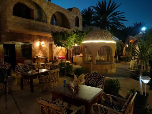a restaurant with tables and chairs and a gazebo at night at Panta Lodge Siwa بنتا لودج سيوة in Siwa
