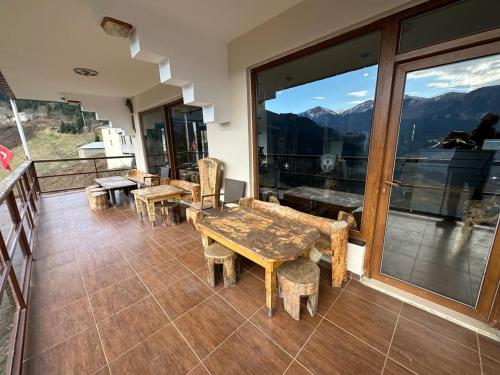 a room with tables and chairs and a view of mountains at MEŞEİÇİ BUTiK HOTEL in Macka