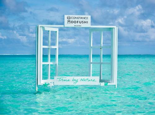 an open door to the ocean with a sign in the water at Constance Moofushi Maldives - All Inclusive in Himandhoo 