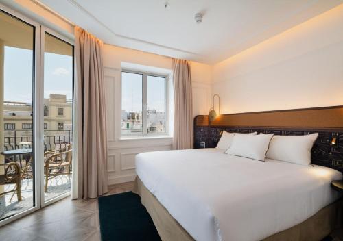 a bedroom with a large bed and a balcony at Only YOU Hotel Valencia in Valencia