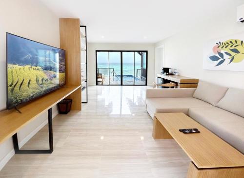 a living room with a couch and a flat screen tv at Phi Phi Holiday Resort, Leam Tong Beach in Phi Phi Don