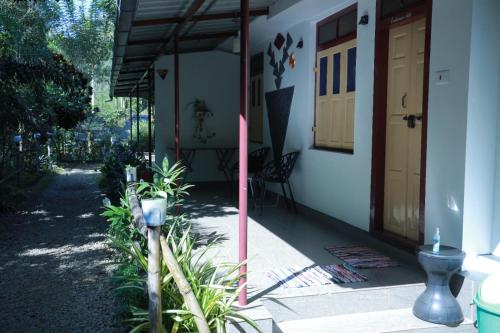 a front porch of a house with a yellow door at SpiceBuds FarmStay - Ramakkalmedu in Idukki